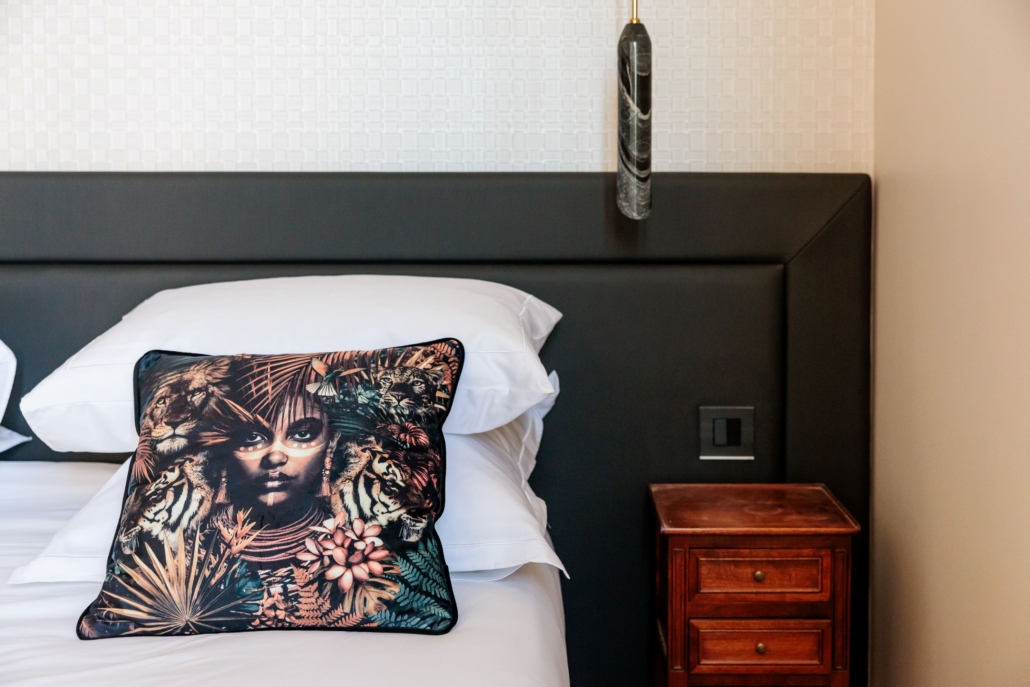 Détail coussin graphique et tête de lit noire — La Villa Kara, Drôme