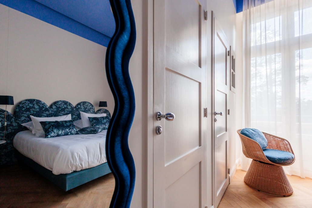 Miroir ondulé bleu et fauteuil en rotin, reflet chambre d'hôtel de charme Élégance Palace Méditerranéen — La Villa Kara