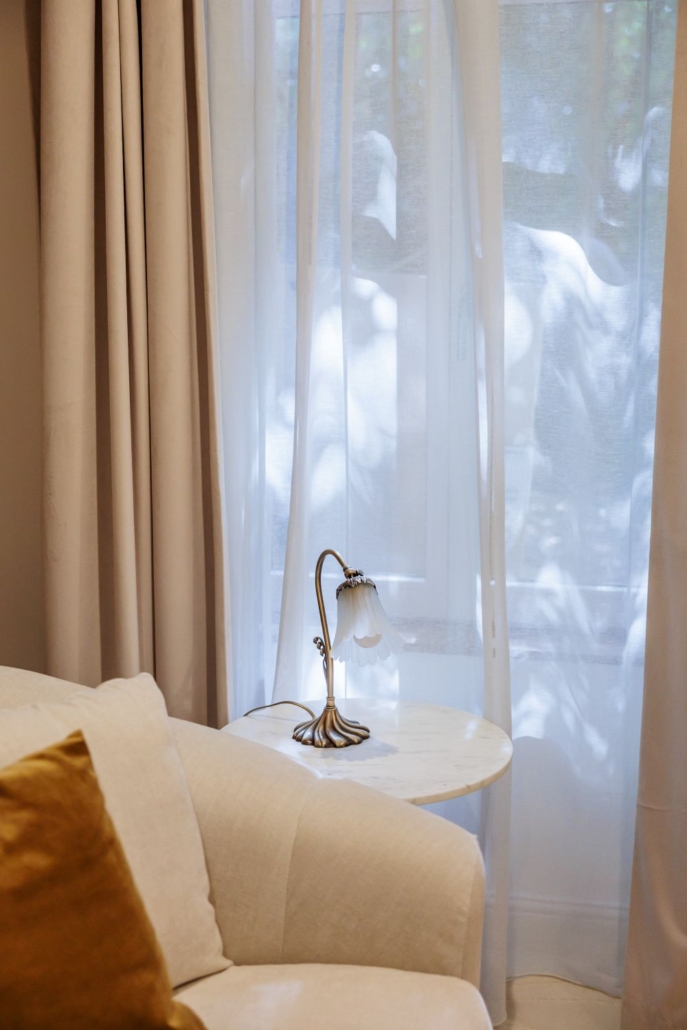 Lampe en laiton à abat-jour fleur de tissu sur table en marbre, détail lumineux de l'hôtel Drôme La Villa Kara