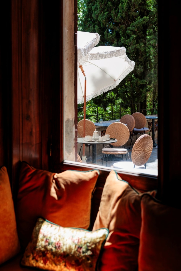 Vue depuis un coin cosy en coussins de velours sur la terrasse et son service à thé, ambiance de l'hôtel La Villa Kara